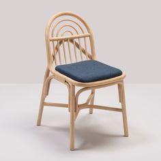 a wooden chair with a blue cushion on the seat and backrest, in front of a gray background