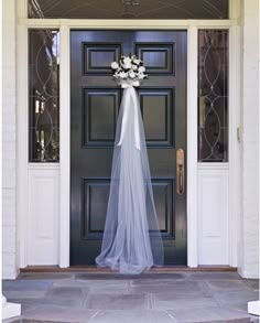 a bride's veil is hanging on the front door