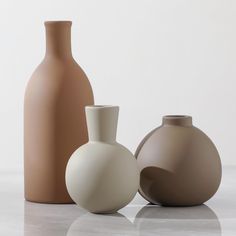 three vases sitting on top of a white table