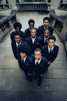 a group of young men in suits and ties posing for a photo on the steps