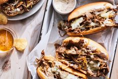 two pulled pork sandwiches on buns with cheese and sauce