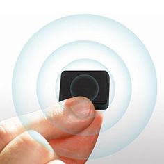 a hand holding a small black object in front of a white background with circles around it