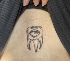 a person with a tattoo on their stomach has an eye in the shape of a tooth