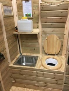 the toilet is made out of pallet wood and has a built in sink area