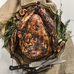 a roasted turkey on a platter with figs and rosemary