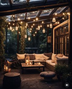 an outdoor living area with lights strung from the ceiling and couches on the deck