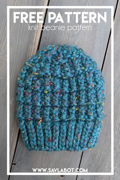 a blue knitted hat with sprinkles on it sitting on top of a wooden floor