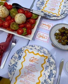 a table topped with plates filled with different types of food next to utensils