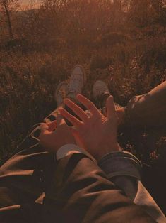 two people laying on the ground with their feet up in the air and one person holding his hand out