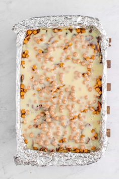 an uncooked casserole covered in cheese and beads