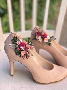 a pair of high heeled shoes with flowers on the heels are sitting on a table