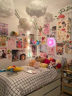 a bed with lots of stuffed animals on it in a room filled with posters and lights