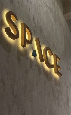 an illuminated sign on the side of a building that says space above it is a blue triangle