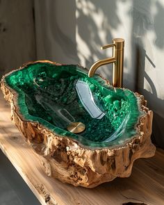 a green glass bowl sink sitting on top of a wooden counter next to a faucet