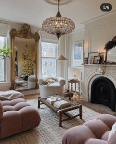 a living room filled with furniture and a fire place under a chandelier in front of a fireplace