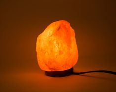 an orange himalayan stone lamp on a brown background