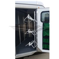 an open door on the side of a white truck with green straps hanging from it's sides