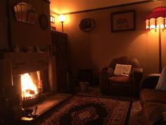 a living room filled with furniture and a fire place next to a chair in front of a fireplace