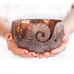 a person holding a bowl in their hands with an artistic design on the inside of it