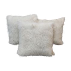 two white fur pillows sitting on top of each other