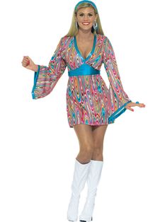 a woman in a colorful dress and white boots is posing for the camera with her arms outstretched