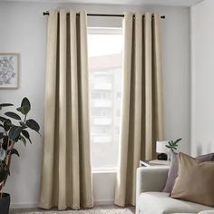 a living room with white walls and beige curtains