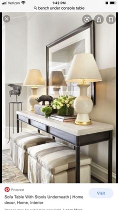 a table with two stools and a mirror on the wall in a living room