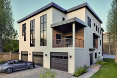 a car is parked in front of a two story house with garages on the second floor