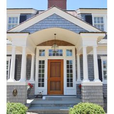 the front entrance of a large house with columns