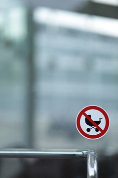 a no skateboarding sign in front of a glass door with a building in the background