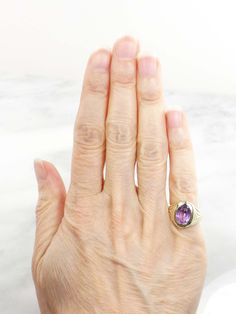 This Vintage 14k Amethyst Ring has clean, elegant lines for a classic look. The setting is 14k yellow gold and showcases a medium tone amethyst stone. The setting has wonderful Art Deco style at the shoulders. The amethyst measures approximately 7.2 x 9.8 x 5.85 mm or approximately 2.2 carats by measurement. The ring is circa the 1930's and under magnification some scratches and abrasions are visible on the stone commensurate with wear. However, this would not be noticeable when the ring is worn Elegant Purple Amethyst Signet Ring, Elegant Amethyst Signet Ring For Formal Occasions, Elegant Formal Amethyst Signet Ring, Oval Amethyst Signet Ring For Formal Occasions, Classic 14k Gold Amethyst Birthstone Ring, Classic Formal Signet Ring With Accent Stones, Classic Amethyst Signet Ring Hallmarked, Classic Purple Gemstone Signet Ring, Classic Hallmarked Amethyst Signet Ring