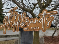 a man standing next to a wooden sign