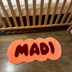 two bath mats with the word mad written on them in front of a crib