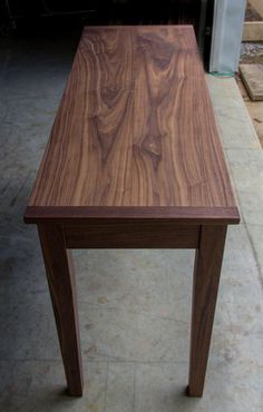 a wooden table sitting on top of a sidewalk