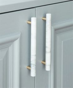 two marble door handles on a gray cabinet