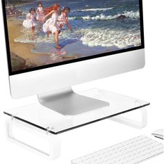 a computer monitor sitting on top of a white desk next to a keyboard and mouse