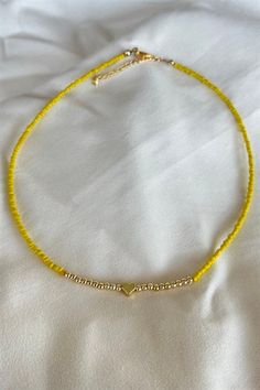 Basic Description: Great simple piece for every occasion. Handmade assorted yellow seed beaded necklace. With gold color heart figure detail. Very lightweight and dainty. Necklaces are joined with a lobster-style clasp and two inch extended chain.  Sizing:  Each necklace is made with a two inch extender chain so the size can be adjusted to your liking. For example, the 16 inch necklace can be extended up to 18 inches. Care: While necklaces will not be damaged by moisture, avoid getting your necklace wet to prevent potential fading or tarnishing. Yellow Seed Bead Necklace, Yellow Beaded Necklace, Seed Beaded Necklace, Dainty Necklaces, 16 Inch Necklace, Color Heart, Seed Bead Necklace, Colorful Heart, Bead Necklace