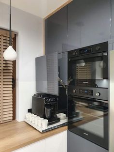 a kitchen with an oven, coffee maker and other items on the counter top in front of it