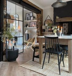 a dining room table and chairs in front of a fire place with candles on it