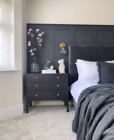 a bedroom with gray walls and white bedding