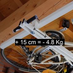 the bike is attached to the wall with two wheels and has an additional rack for it