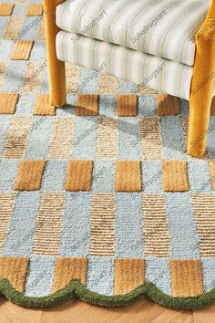 a chair sitting on top of a wooden floor next to a blue and yellow rug