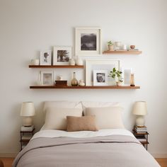 a bed with two shelves above it and pictures on the wall