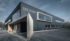 an empty parking lot in front of a building with windows on each side and the words zon eicher written on it