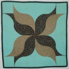 a blue and brown quilt with leaves on it