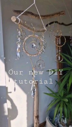 a wind chime hanging from the side of a wall next to a potted plant