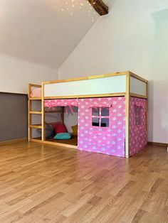 there is a bunk bed in the middle of this room with pink sheets on it