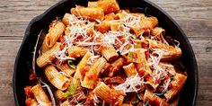 a skillet filled with pasta covered in sauce and parmesan cheese