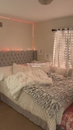 a large bed sitting in the middle of a room with lights on either side of it