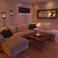 a living room filled with furniture and a lit candle on top of a coffee table